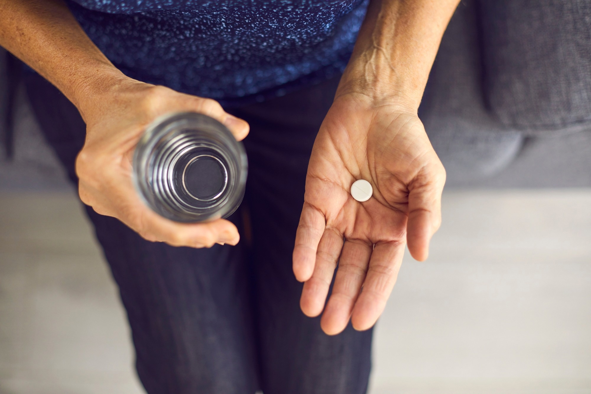 Person holding two pill containers highlighting low-dose aspirin to reduce Type 2 diabetes risk