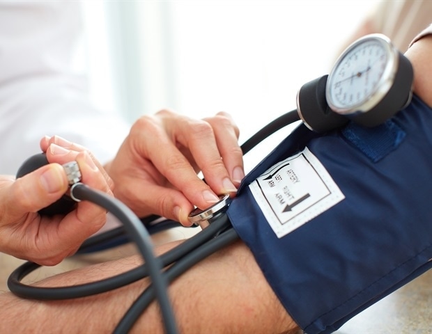 A person receives a blood test while wearing a blood pressure monitor, demonstrating the importance of blood pressure monitoring for adults with diabetes.
