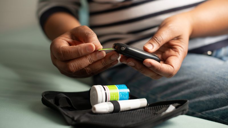 Child using glucose meter in low-income setting; highlighting diabetes care gap