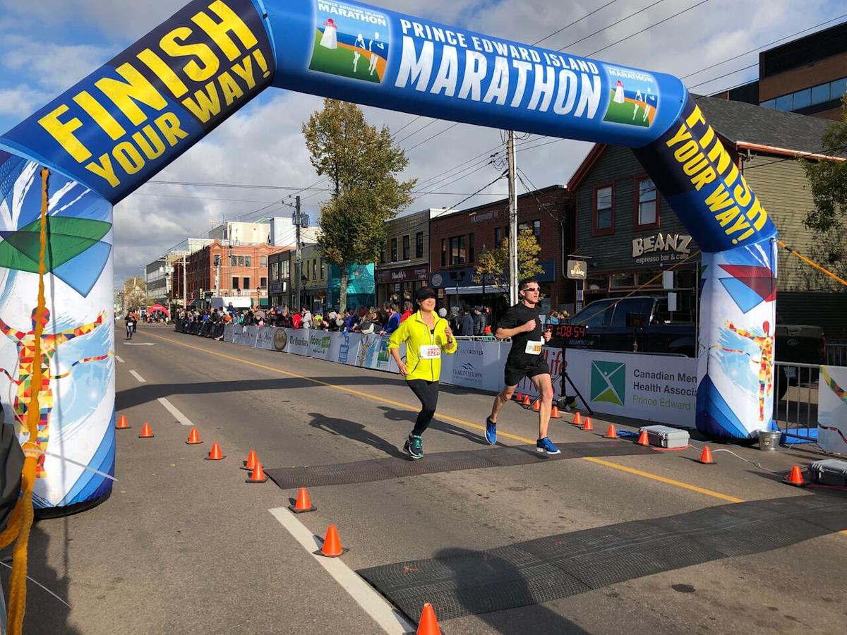 A runner crossing the finish line under a blue arch, determined to qualify for the Boston Marathon despite his diabetes diagnosis