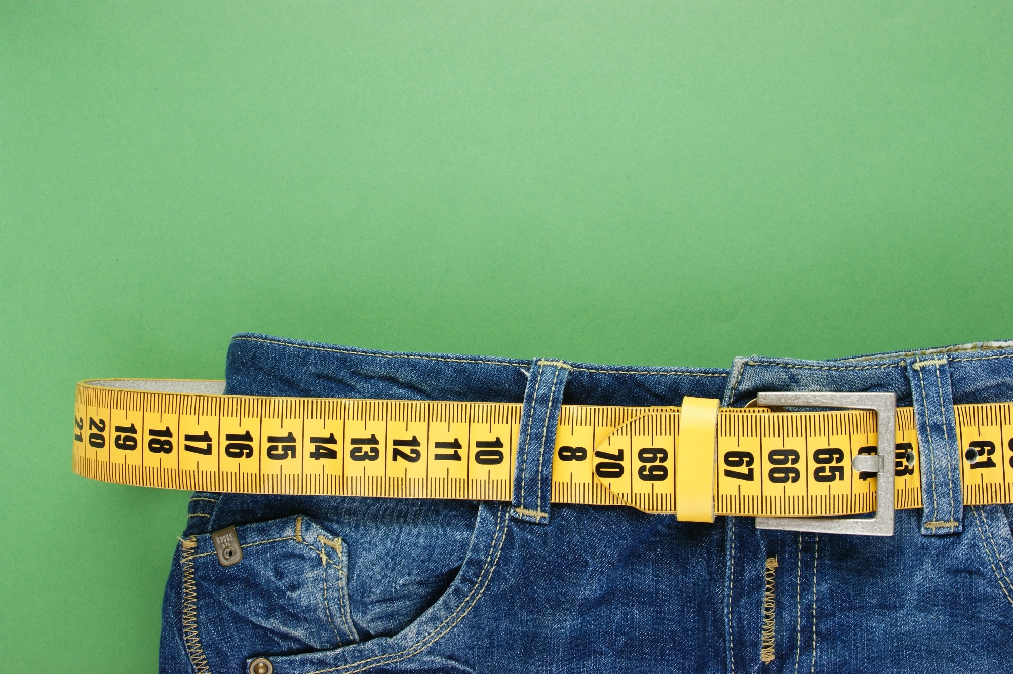 Jeans and tape measure showing tirzepatide weight loss